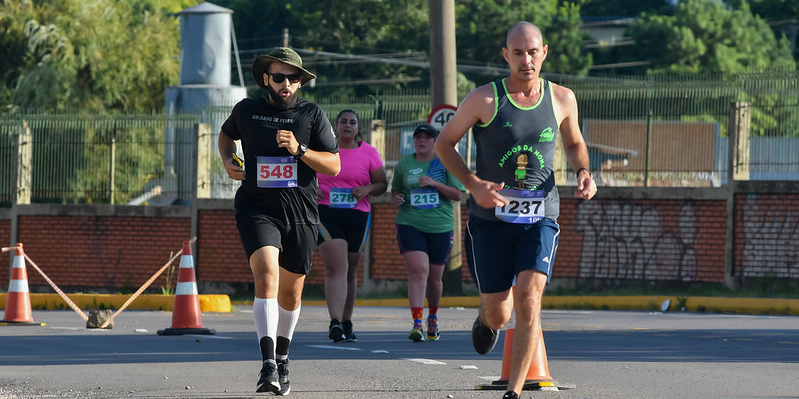 Quatro pessoas correndo na rua, disputando uma maratona