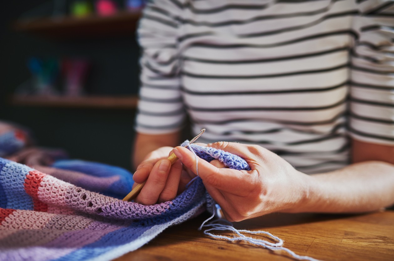 A imagem mostra uma pessoa tricotando.