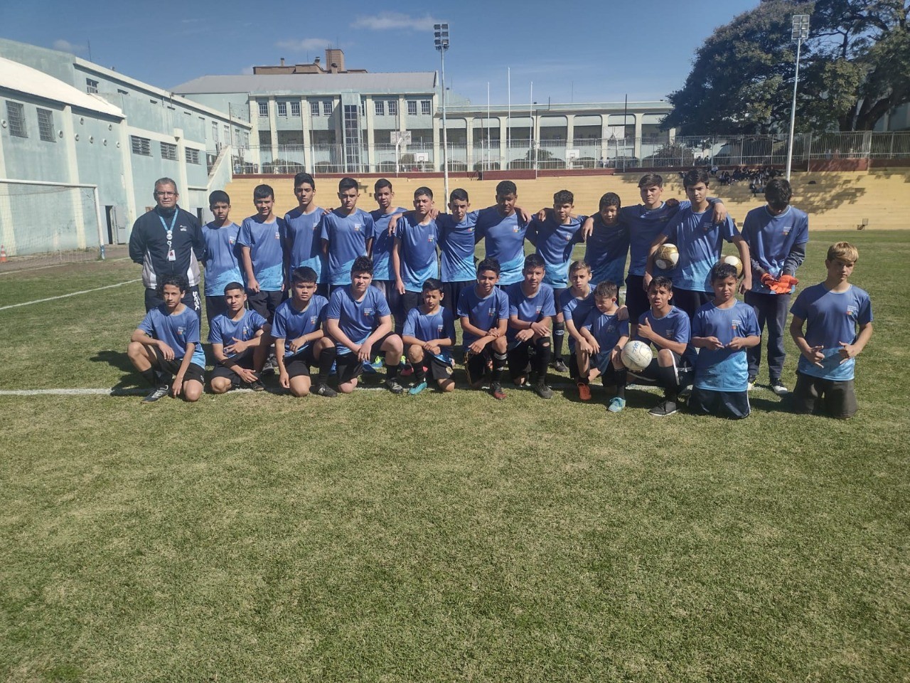 Alunos de futebol da Iniciação Esportiva do Sesc Uruguaiana postados para foto no campo.