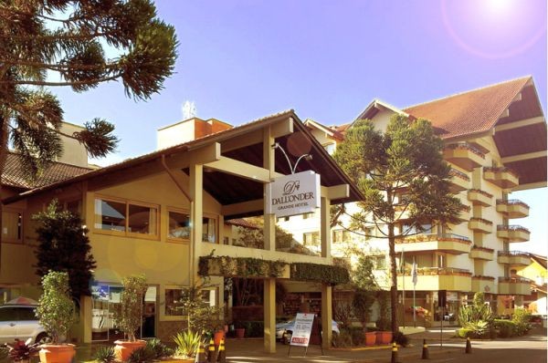 Fachada do hotel Dall’Onder, em Bento Gonçalves, com céu azul e árvores.