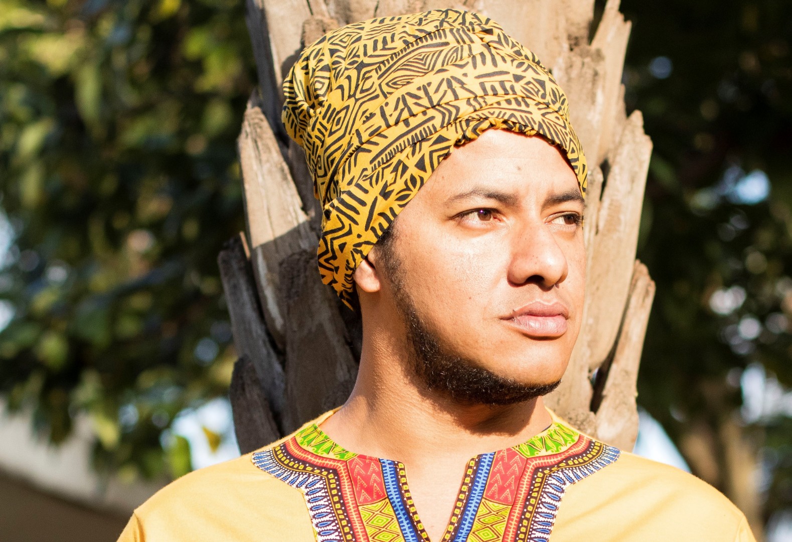 Escritor Vinícius Brasil utilizando roupas da cultura africana.