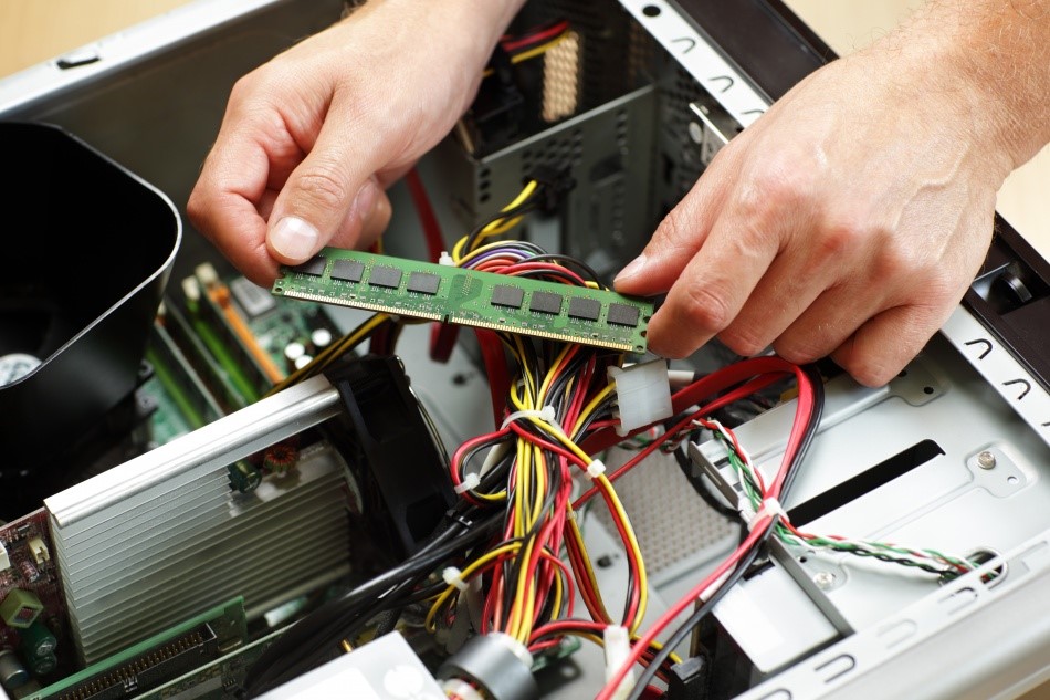 Mãos manuseando peças de computadores.