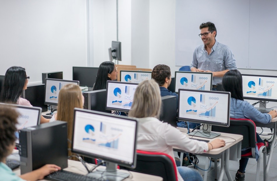 Pessoas utilizando computadores na sala de aula.