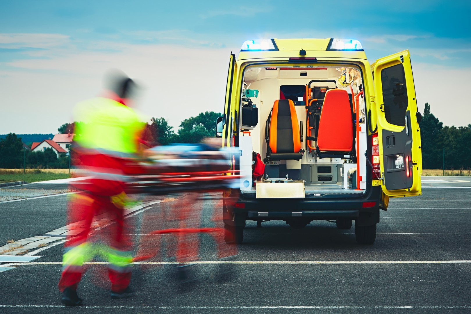 Serviço médico de emergência. O paramédico está puxando a maca com o paciente para o carro da ambulância.