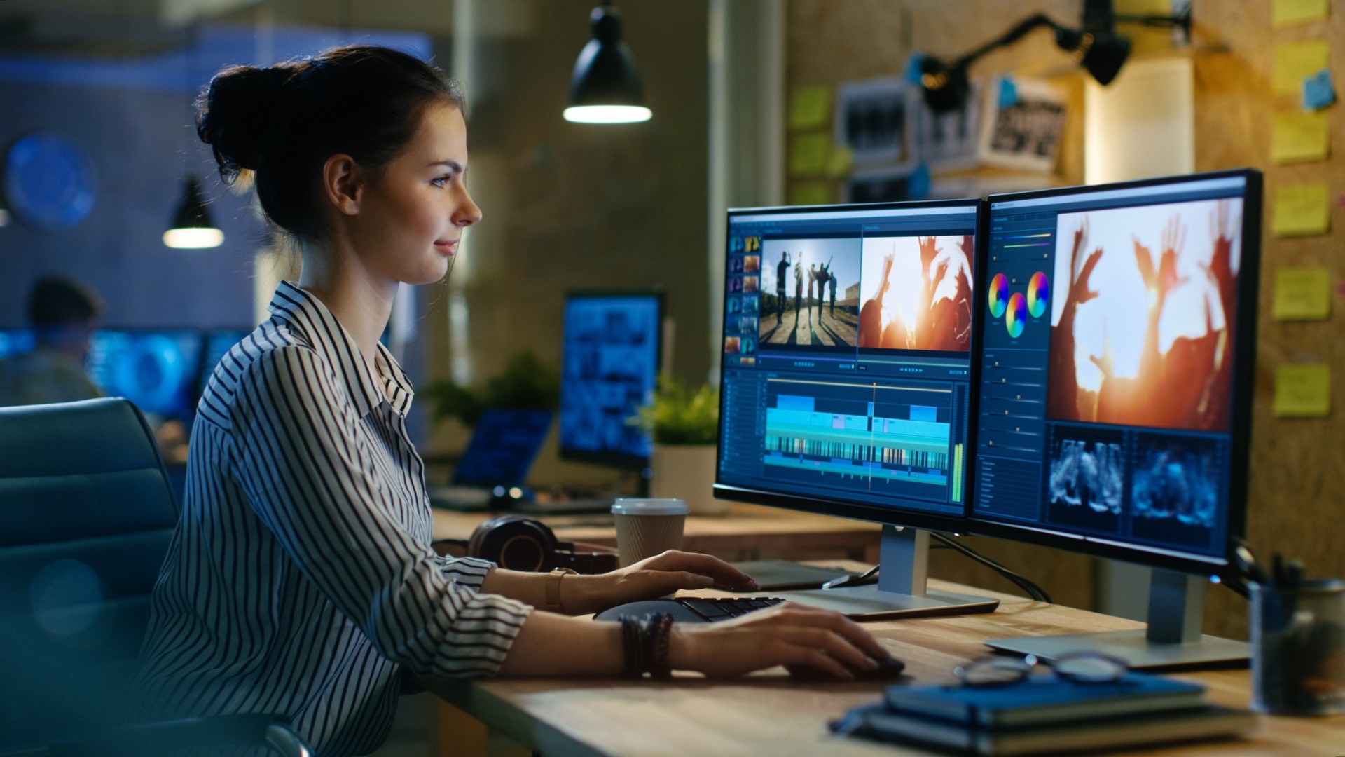 Editor de vídeo feminino lindo trabalha com imagens em seu computador pessoal, ela trabalha no escritório criativo Studio.