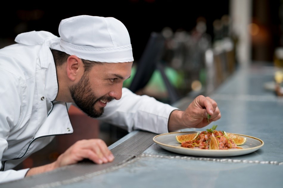 Homem decorando um prato de comida.