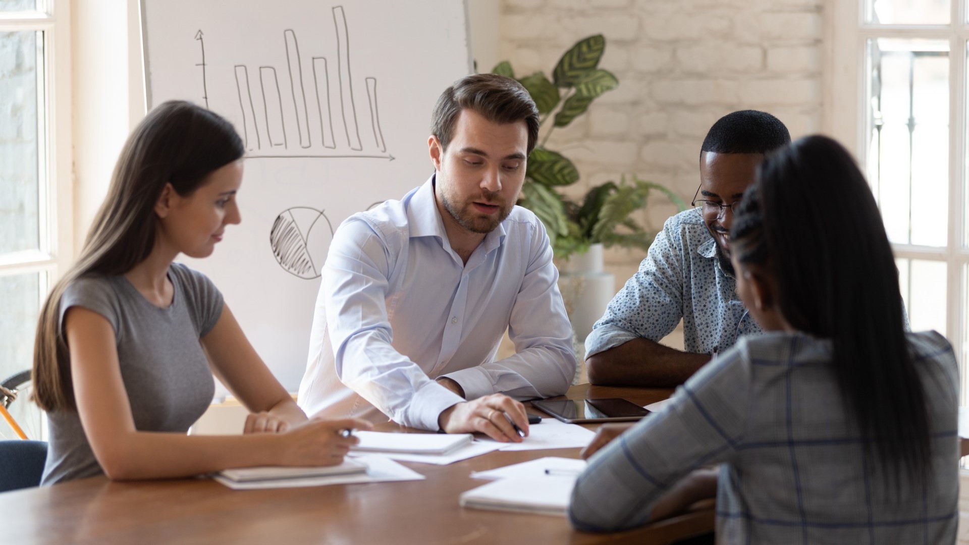 Estagiários multinacionais obtêm conhecimento de um treinador especializado em negócios participa de seminário corporativo, a equipe da empresa ouve o líder da equipe fazendo papelada discutindo tarefas juntos, trabalho em equipe e conceito de orientação